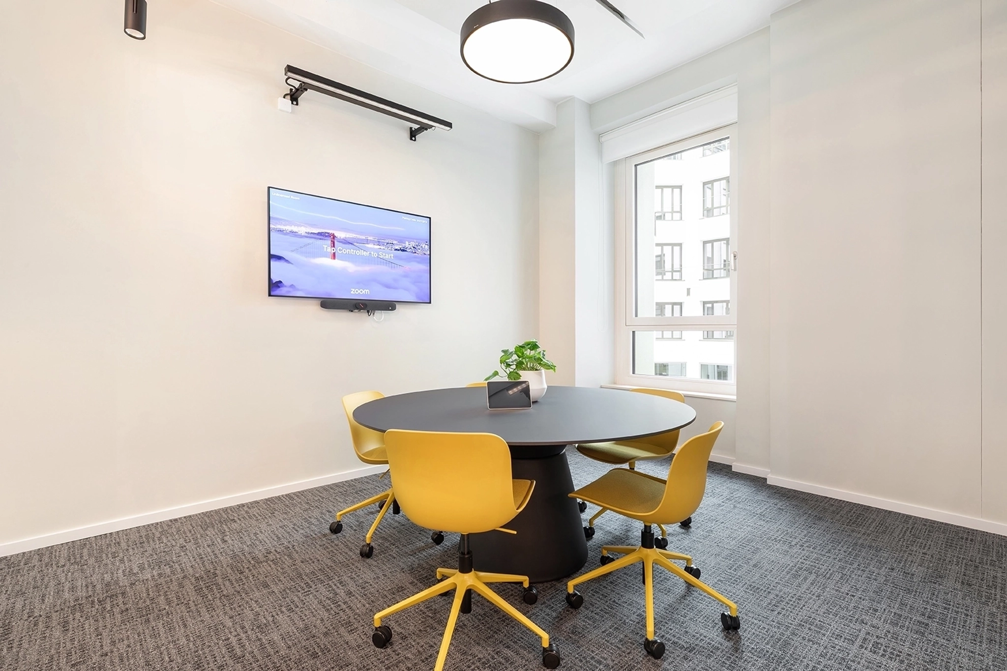 Ein großer, heller Besprechungsraum mit einem großen Bildschirm